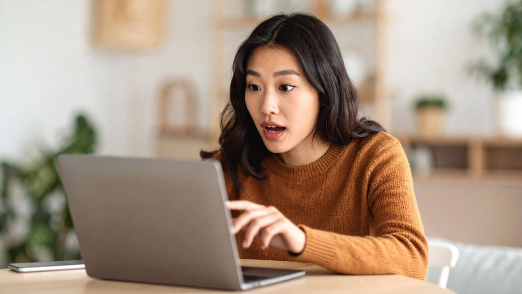 海外サイトを調べながら期待と不安が入り混じった表情の女性
