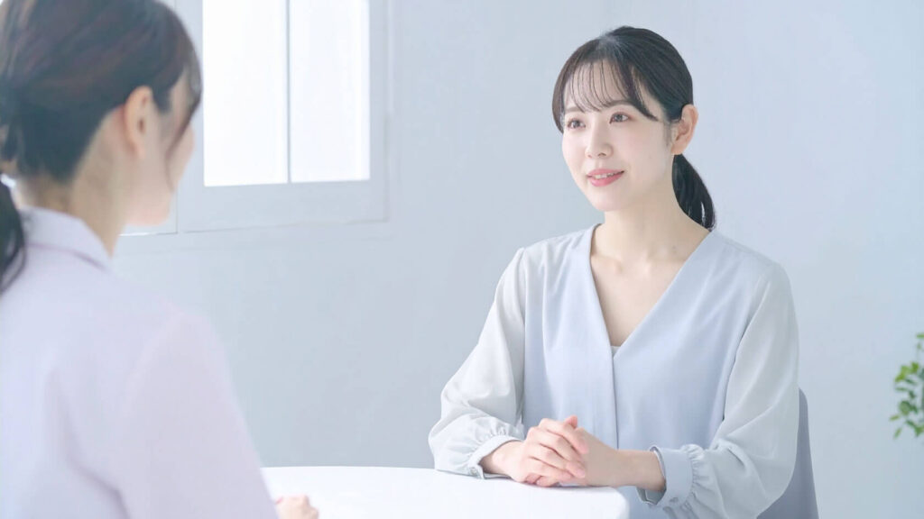 事務所スタッフと話している最中、不安そうな表情を見せる女性