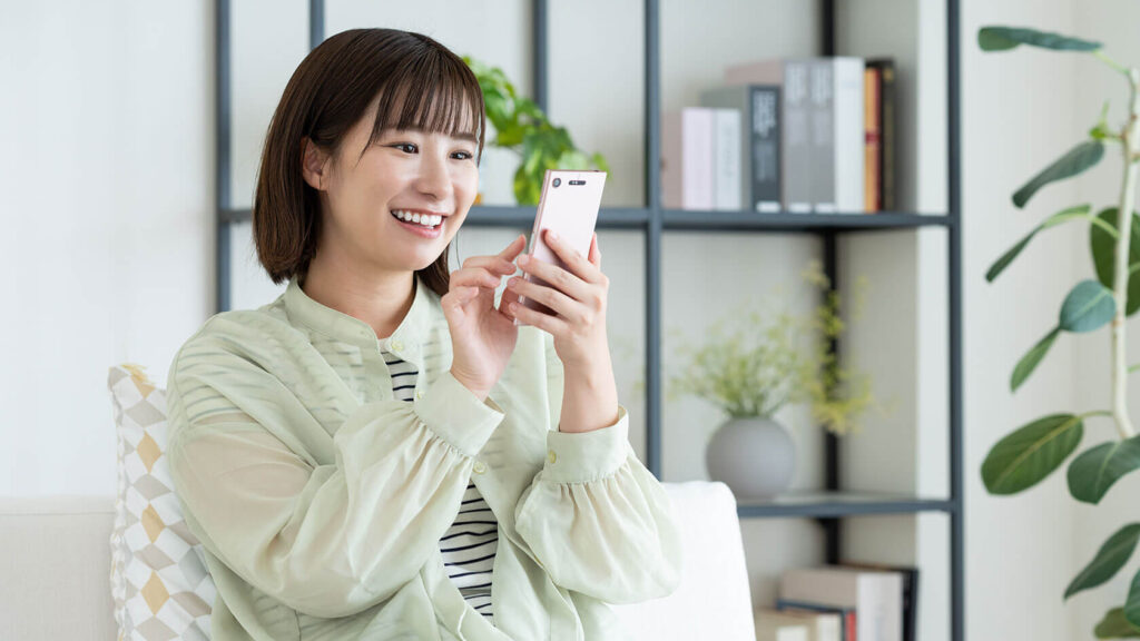 スマートフォンに文章を入力する女性、自己紹介文を作成しているチャットレディのイメージ